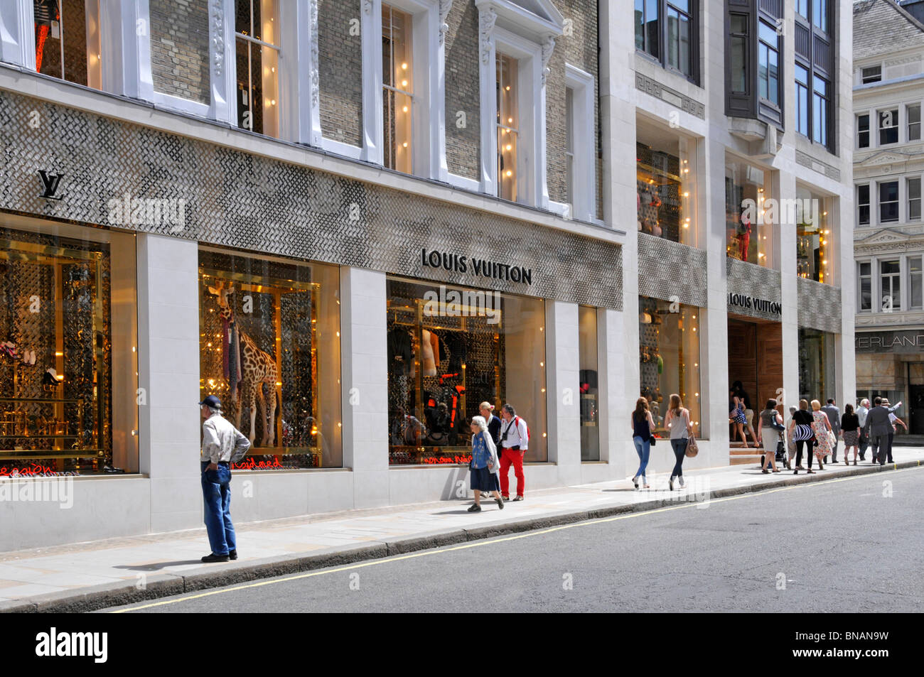 Louis Vuitton magasin de mode de luxe français avant et fenêtre décorée affiche le jour d'été ensoleillé dans New Bond Street Mayfair West End Londres Angleterre Royaume-Uni Banque D'Images