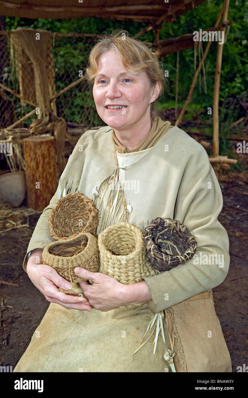 Un interprète vêtu comme un Indien Powhatan paniers détient elle a tissé de montrer aux visiteurs la vie dans le début des années 1600, à Jamestown Settlement, Virginie. Banque D'Images