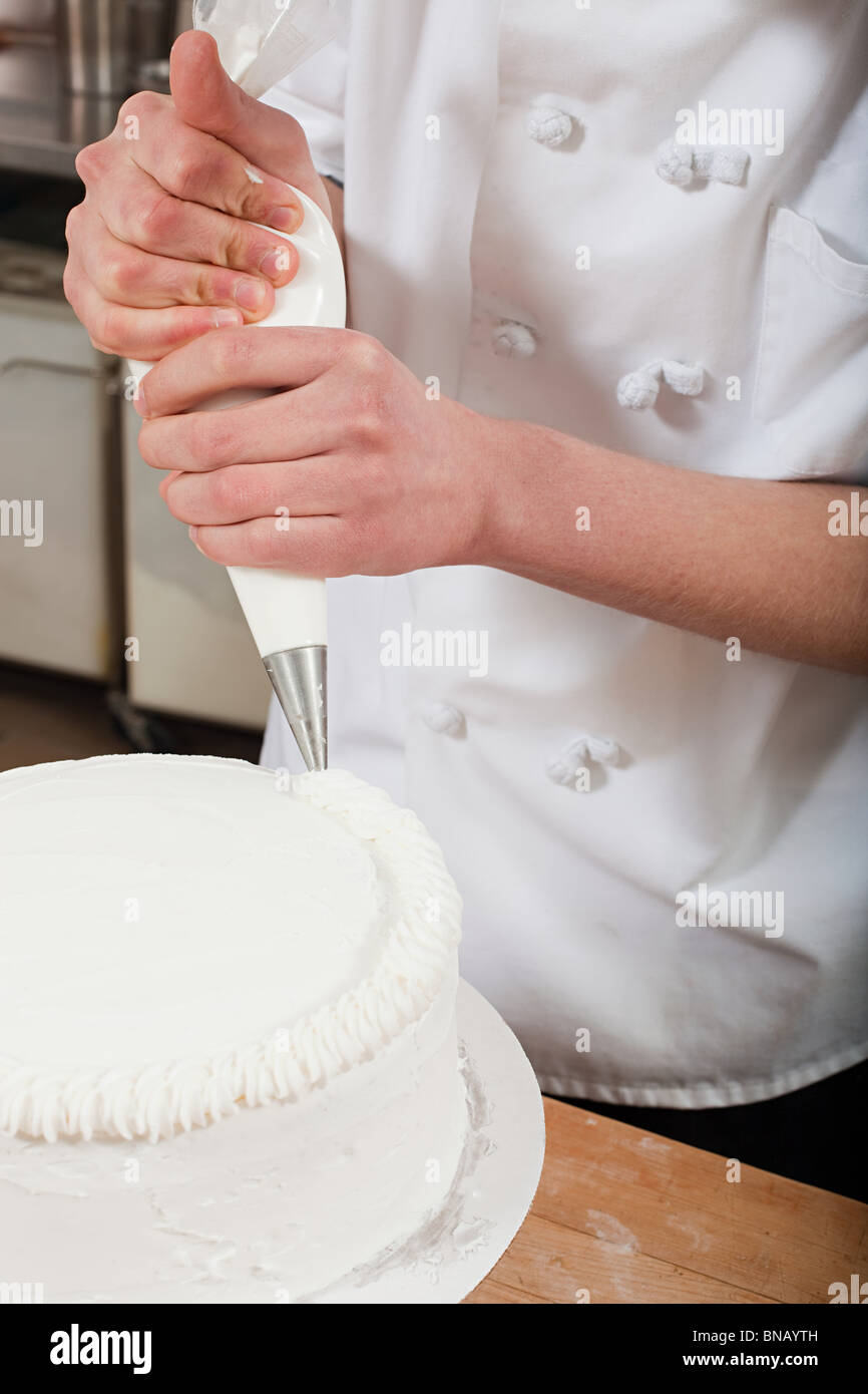 Femme chef d'un gâteau de givrage Banque D'Images