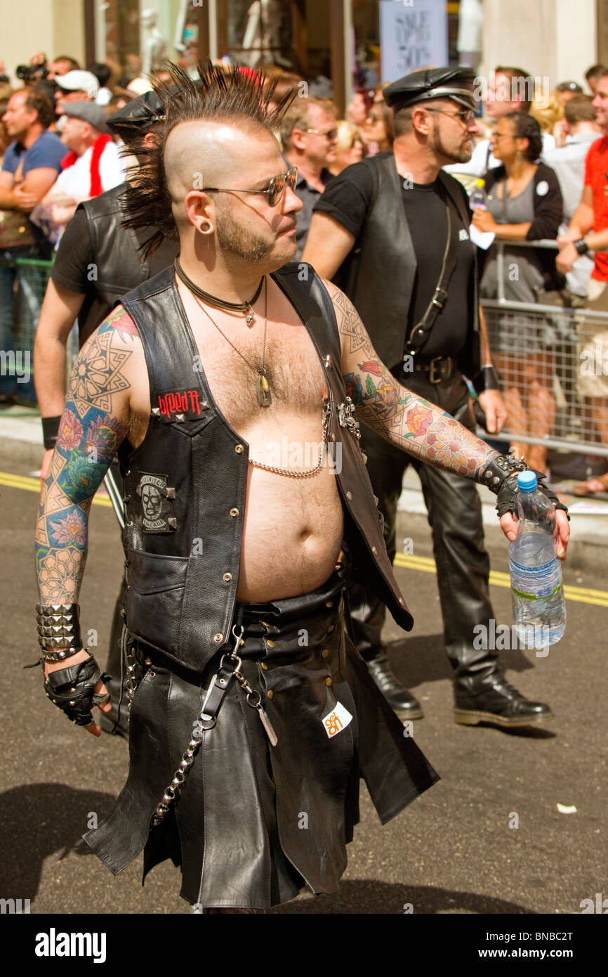 Londres Gay Pride , chubby garçon ou un homme en gilet de cuir & jupe gants & coiffure Mohican , tatouages , , chaînes big earring Banque D'Images