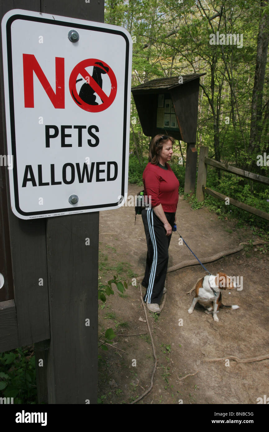 Les animaux domestiques ne sont pas admis parc sign woman walking dog en Ohio Banque D'Images