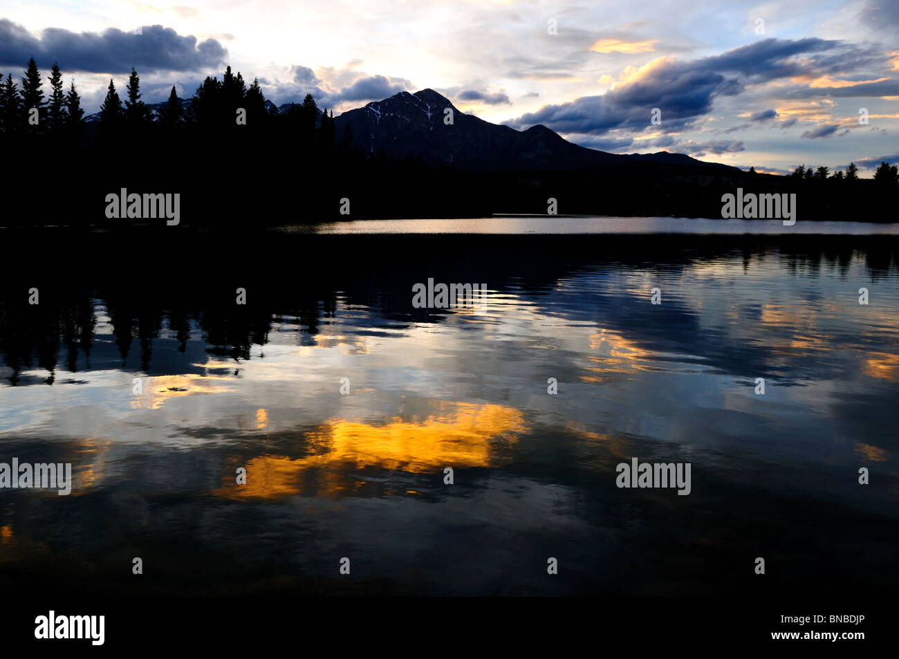 Les nuages colorés et des réflexions dans le lac. Le Parc National Jasper, Alberta, Canada. Banque D'Images