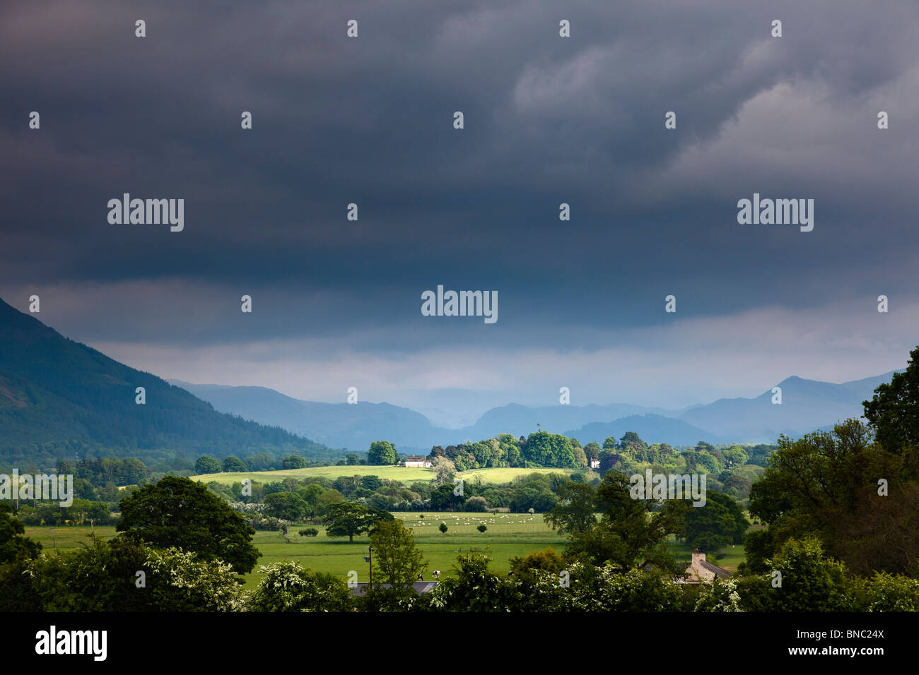 Ciel d'orage - La lumière se brisant sur un champ et ferme pendant une tempête dans le Lake District, Cumbria, Angleterre, Royaume-Uni Banque D'Images