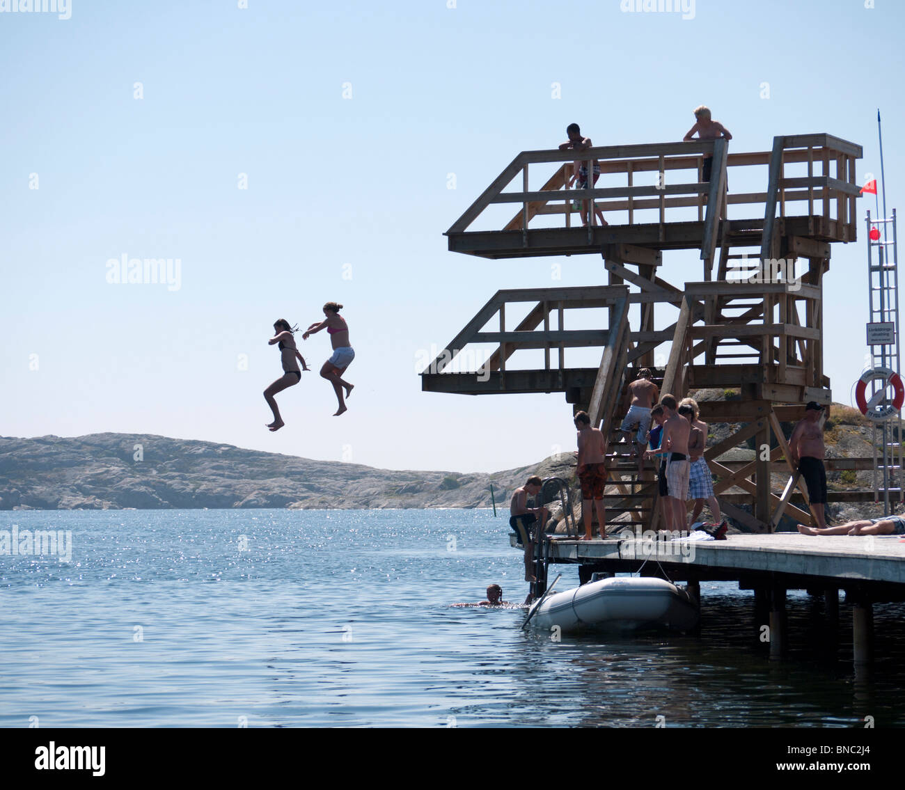 Les enfants sauter de plates-formes de plongée en mer au cours de l'été à Skarhamn sur la côte ouest de la Suède sweden Banque D'Images