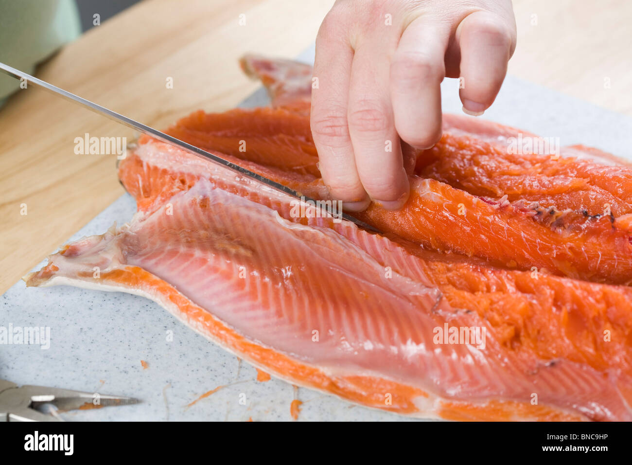 Personne et de désossage de coupe filet de saumon. Banque D'Images