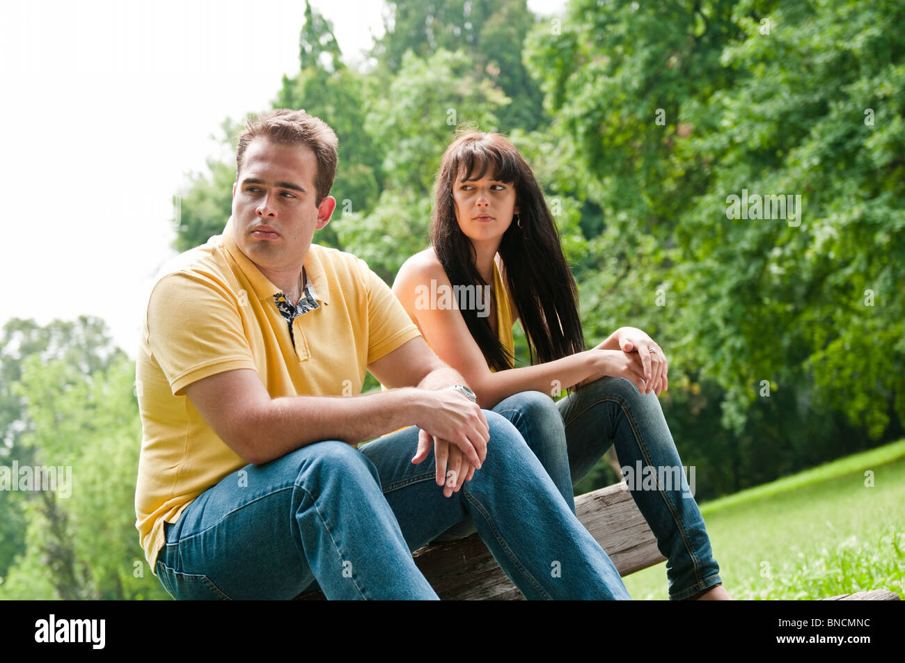 Jeune couple assis sur un banc à l'extérieur ayant des problèmes relationnels Banque D'Images