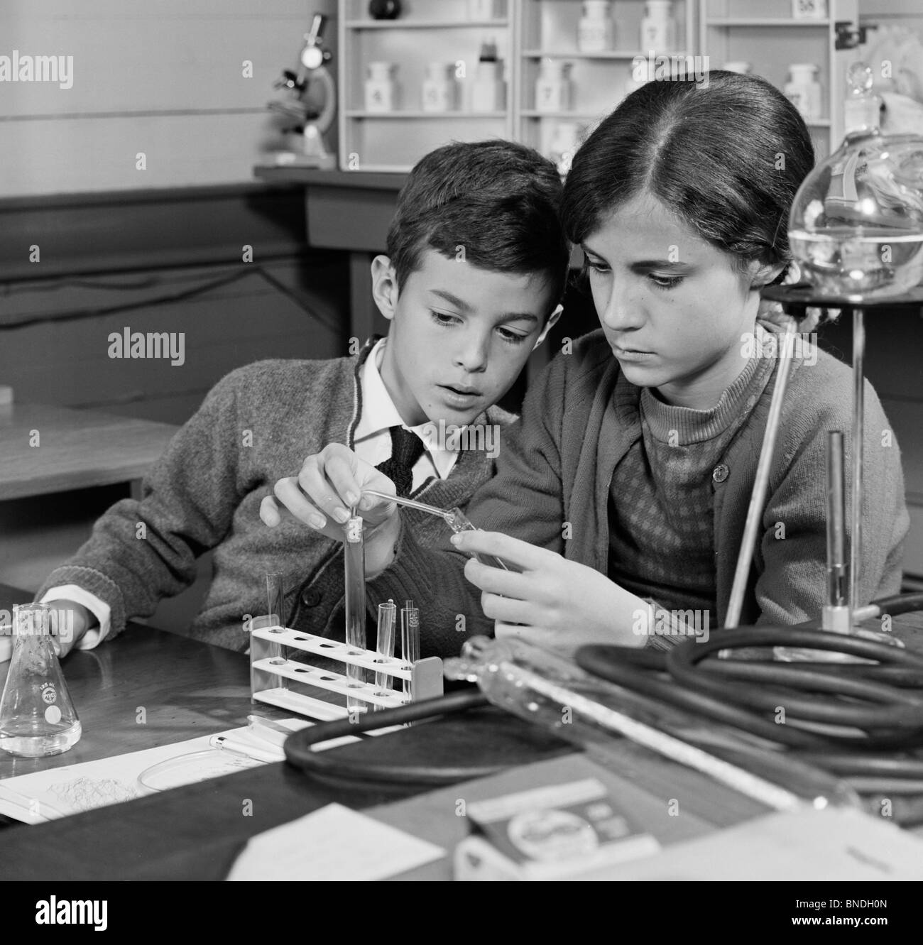 Garçon et une fille d'effectuer une expérience dans un laboratoire de chimie Banque D'Images