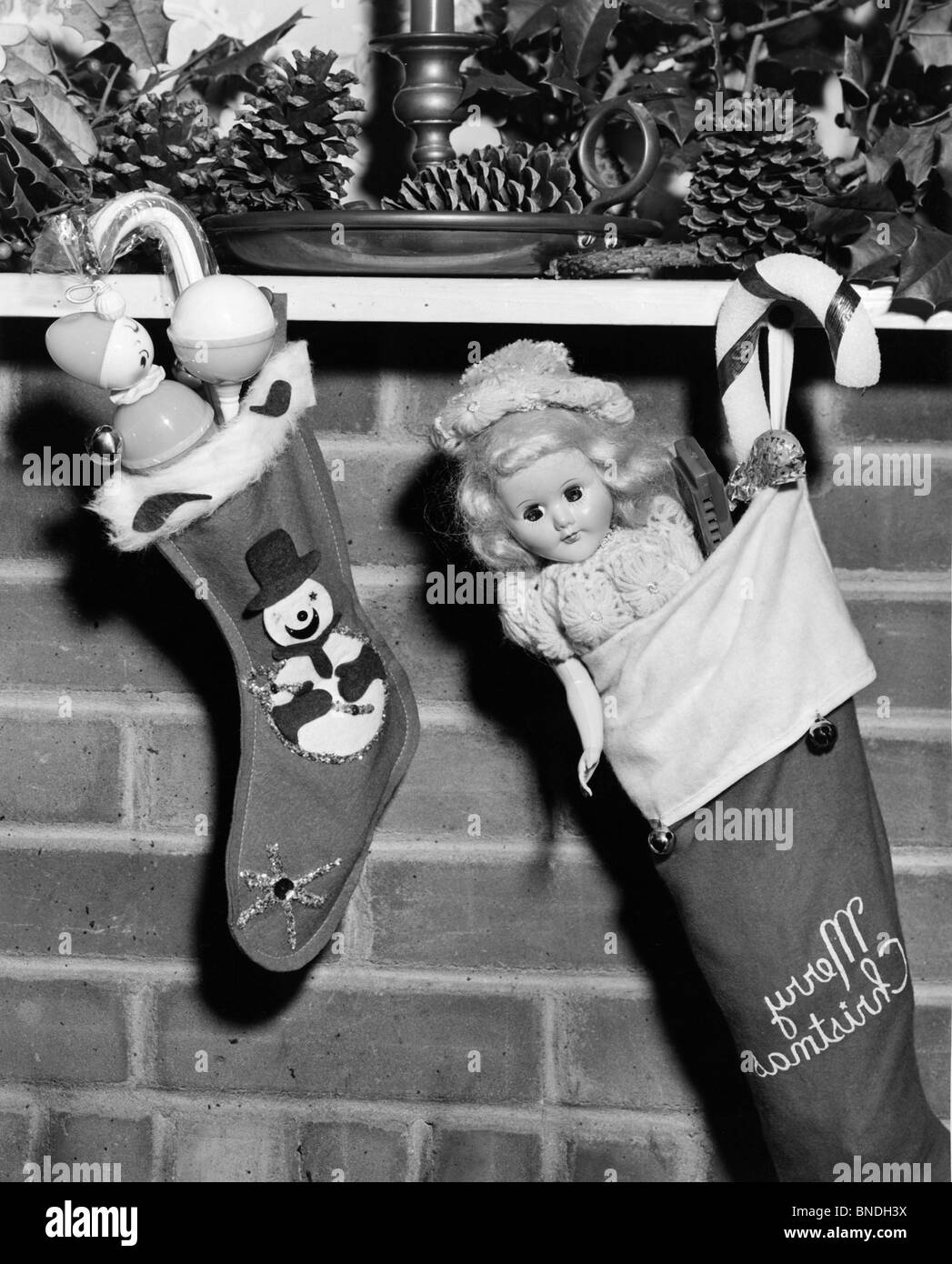 Close-up de deux bas de Noël remplis de jouets suspendus à un cheminée Banque D'Images