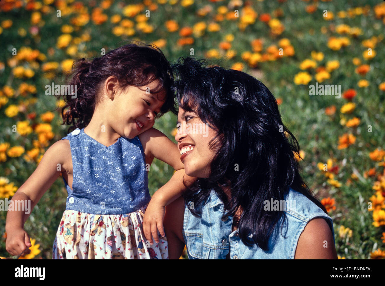Heureuse mère et fille 4 ans fille fleurs champ souriant.multi inter ethniques raciales diversifiées Filipina Banque D'Images