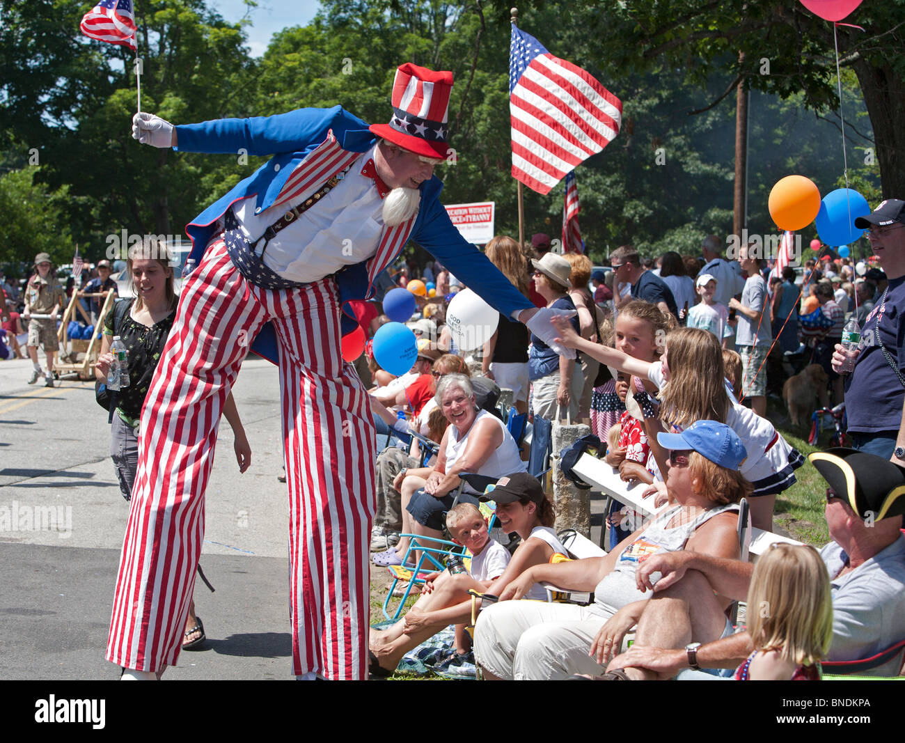 Amherst, New Hampshire - Oncle Sam sur pilotis salue la foule lors de la parade du 4 juillet dans une petite ville de la Nouvelle-Angleterre. Banque D'Images