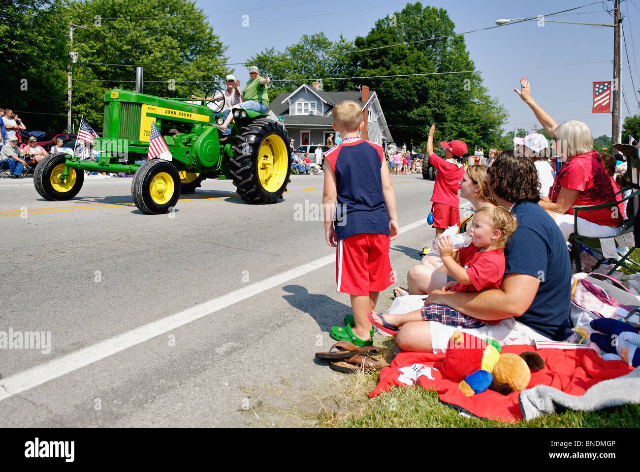 L'observation de la famille d'un tracteur John Deere dans la plus ancienne Indépendance Day Parade en Amérique à Pekin, Indiana Banque D'Images