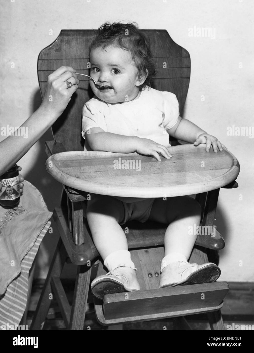 L'alimentation de bébé dans une chaise haute Banque D'Images