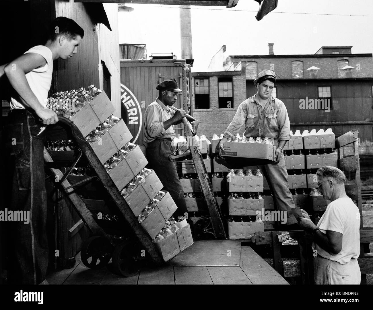 Groupe d'hommes travaillant dans une usine d'embouteillage du lait, 1951 Banque D'Images