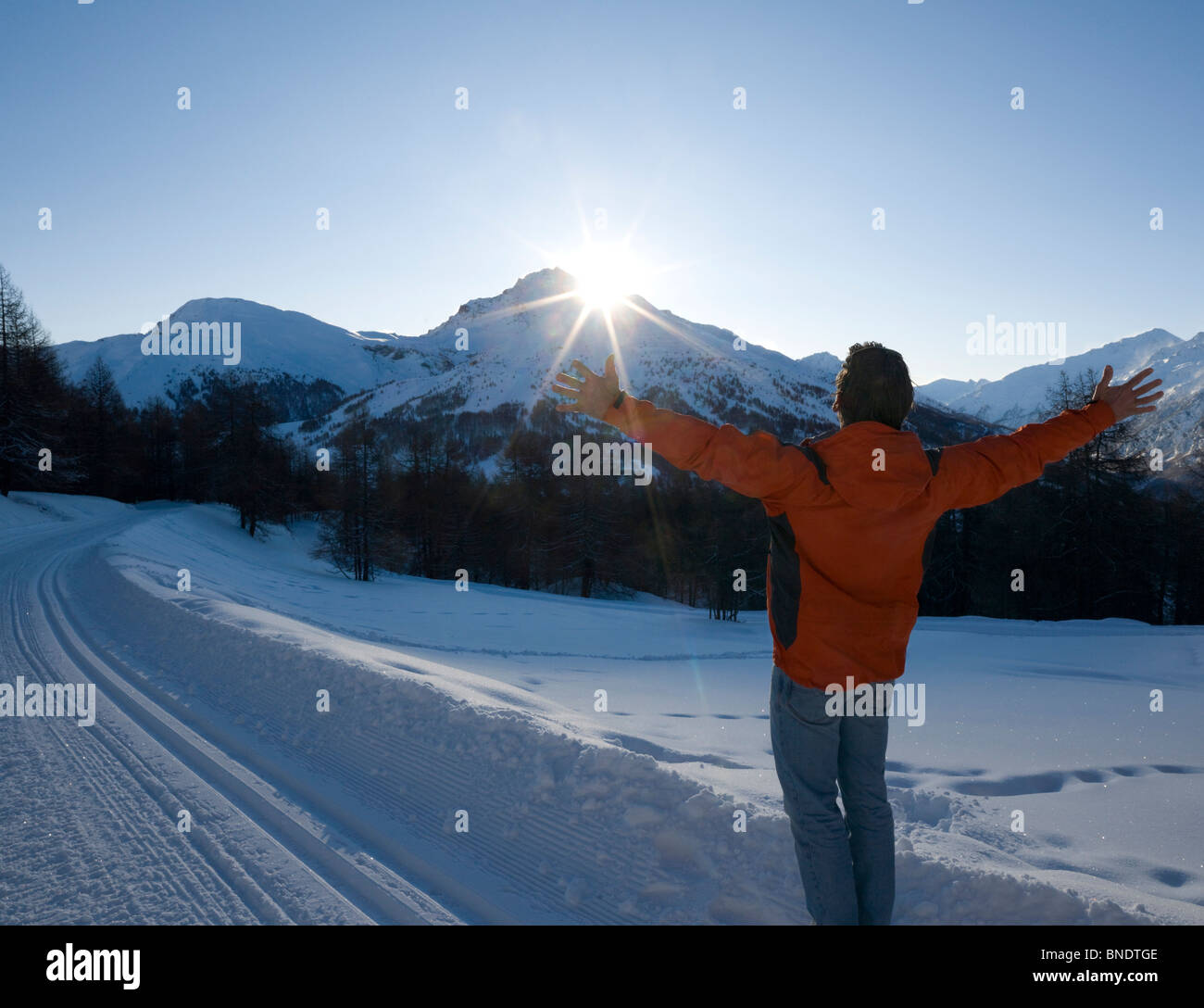 Homme debout avec ses bras tendus sur piste de ski Banque D'Images