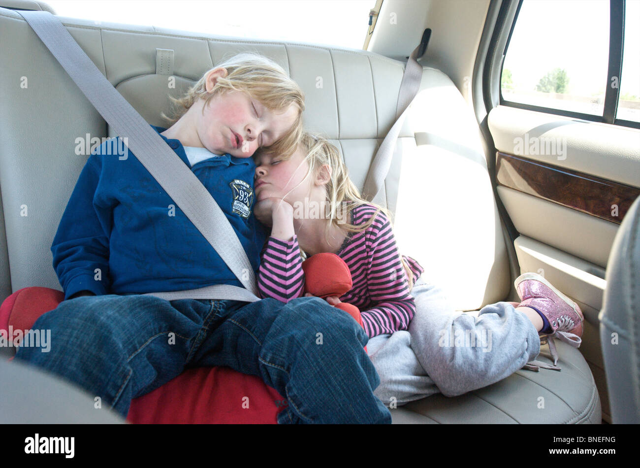 Frère et soeur dormir sur siège arrière de la voiture Banque D'Images