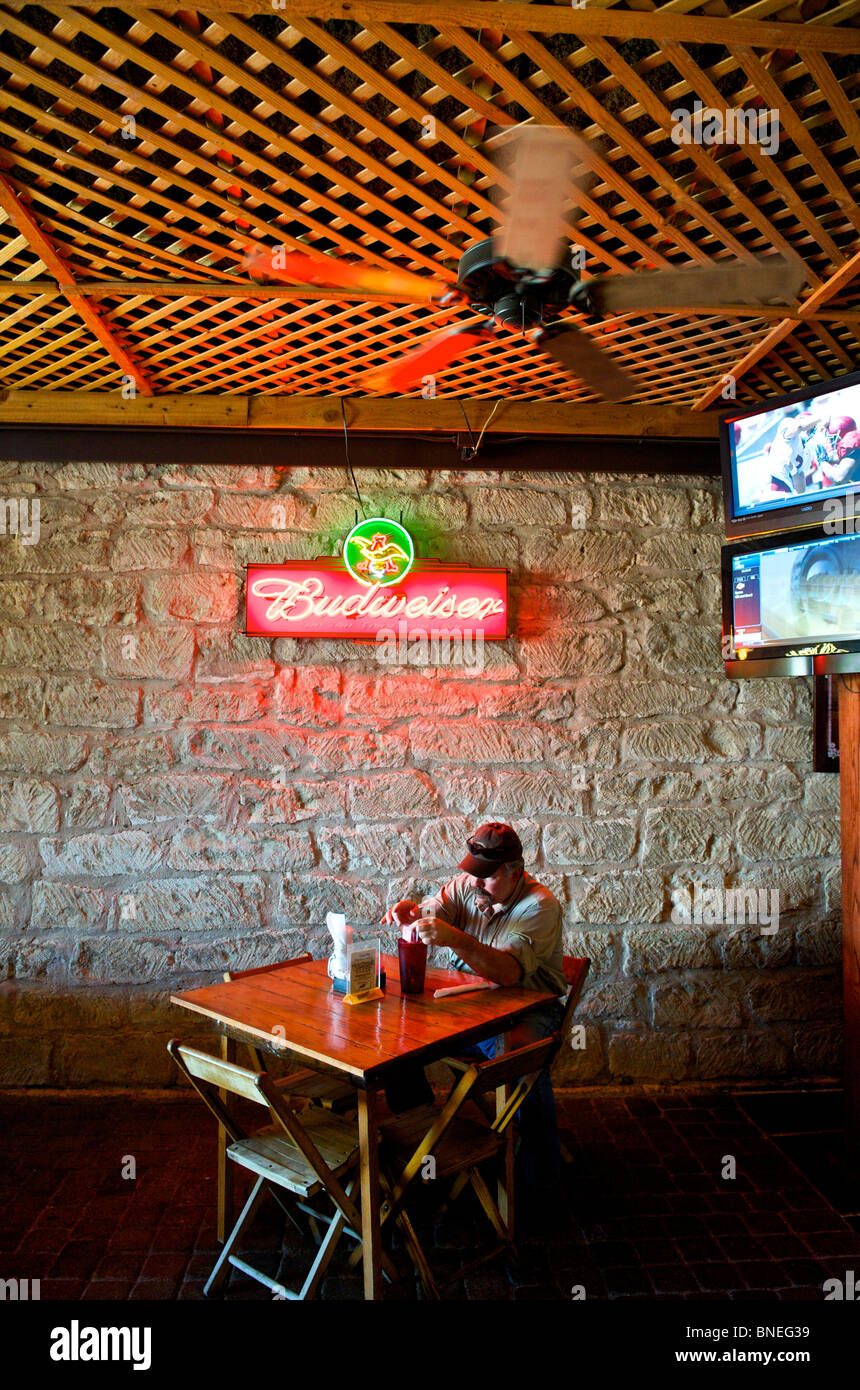 Un homme assis seul dans le restaurant Biergarten Auslander et Hill Country Fredericksburg, au Texas, USA Banque D'Images