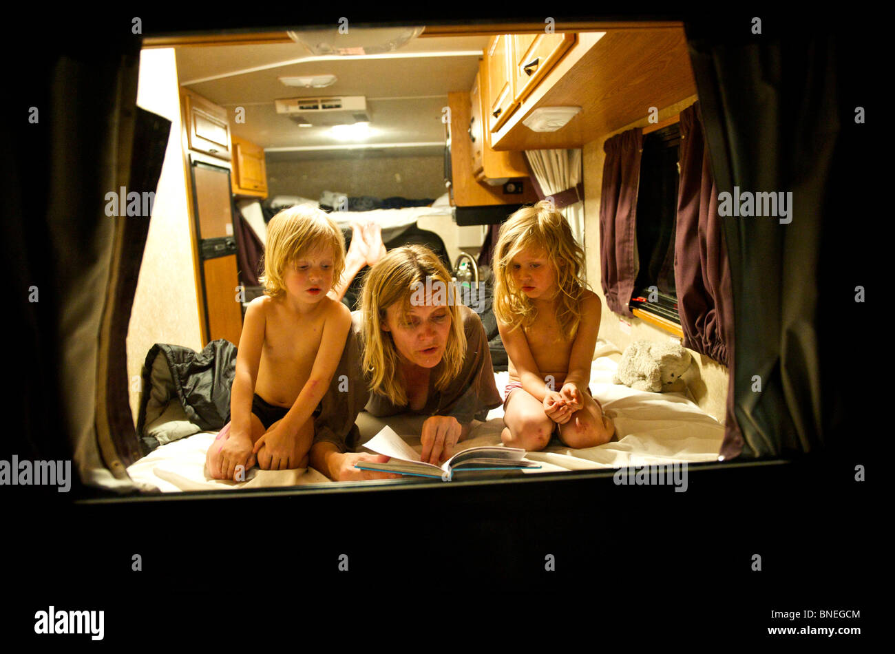 Lire une histoire avant de la mère pour ses enfants dans un camping-car RV dans le Texas, USA Banque D'Images
