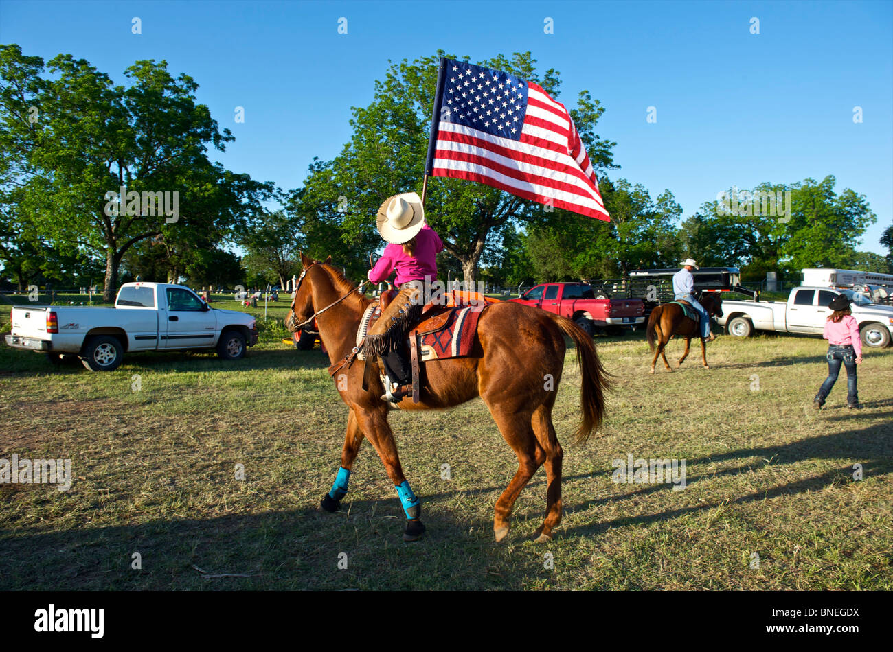 Cowgirl waving flag en bestiaux avant la cérémonie d'ouverture de l'érythroblastopénie événement rodéo au Texas, USA Banque D'Images