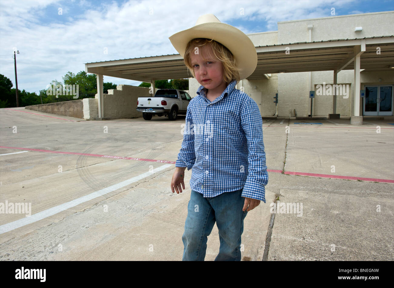 Jeune cowboy posing in front of building à Petite-ville Texas, États-Unis Banque D'Images
