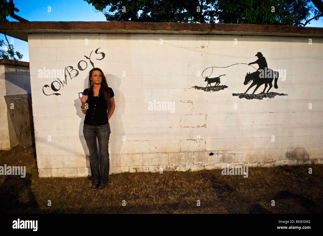 Femme debout en face des toilettes d'une petite ville PRCA Rodeo Bridgeport, Texas, États-Unis Banque D'Images