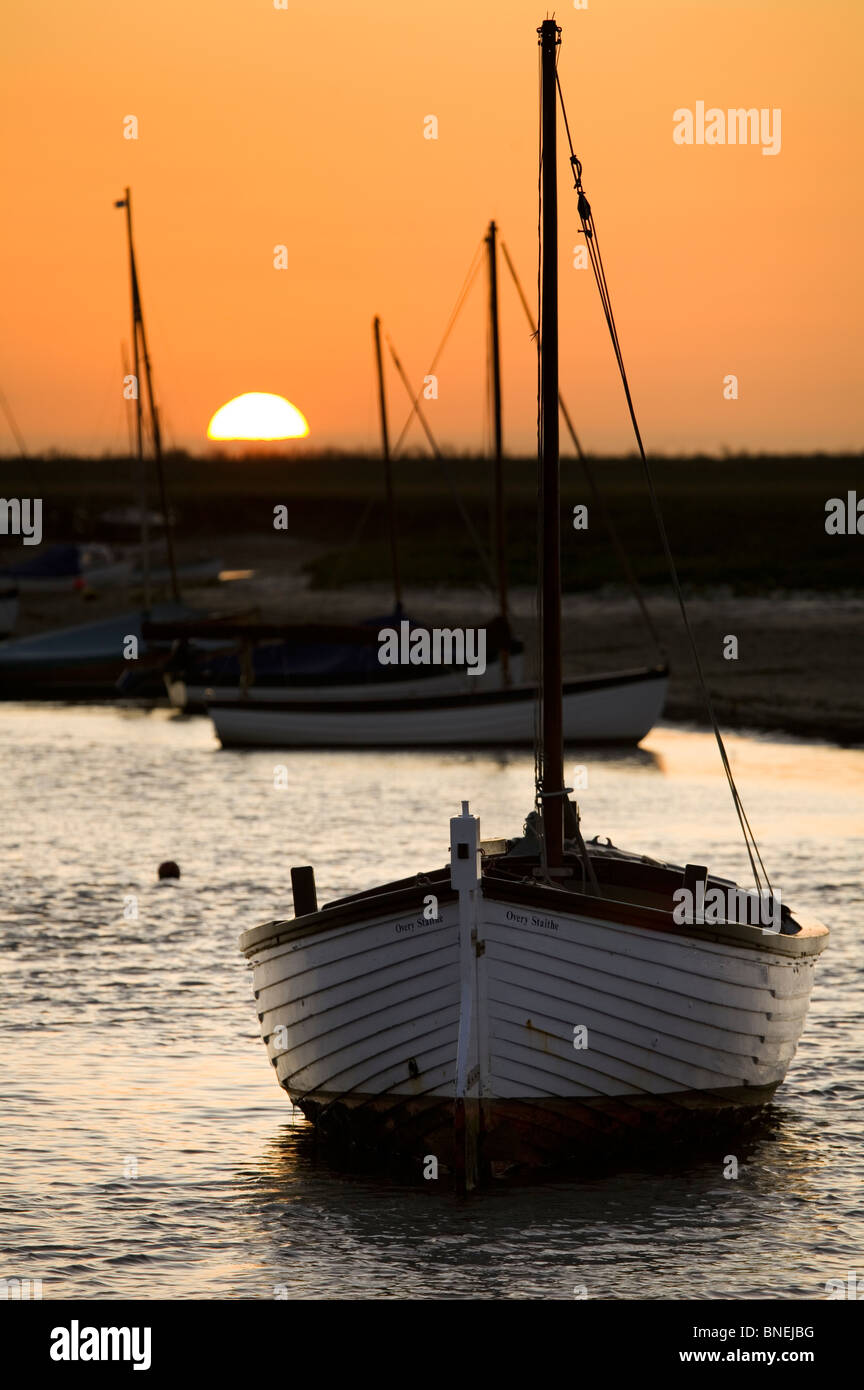 Le soleil derrière des bateaux amarrés sur le fleuve de gravure à Burnham Overy Staithe Banque D'Images