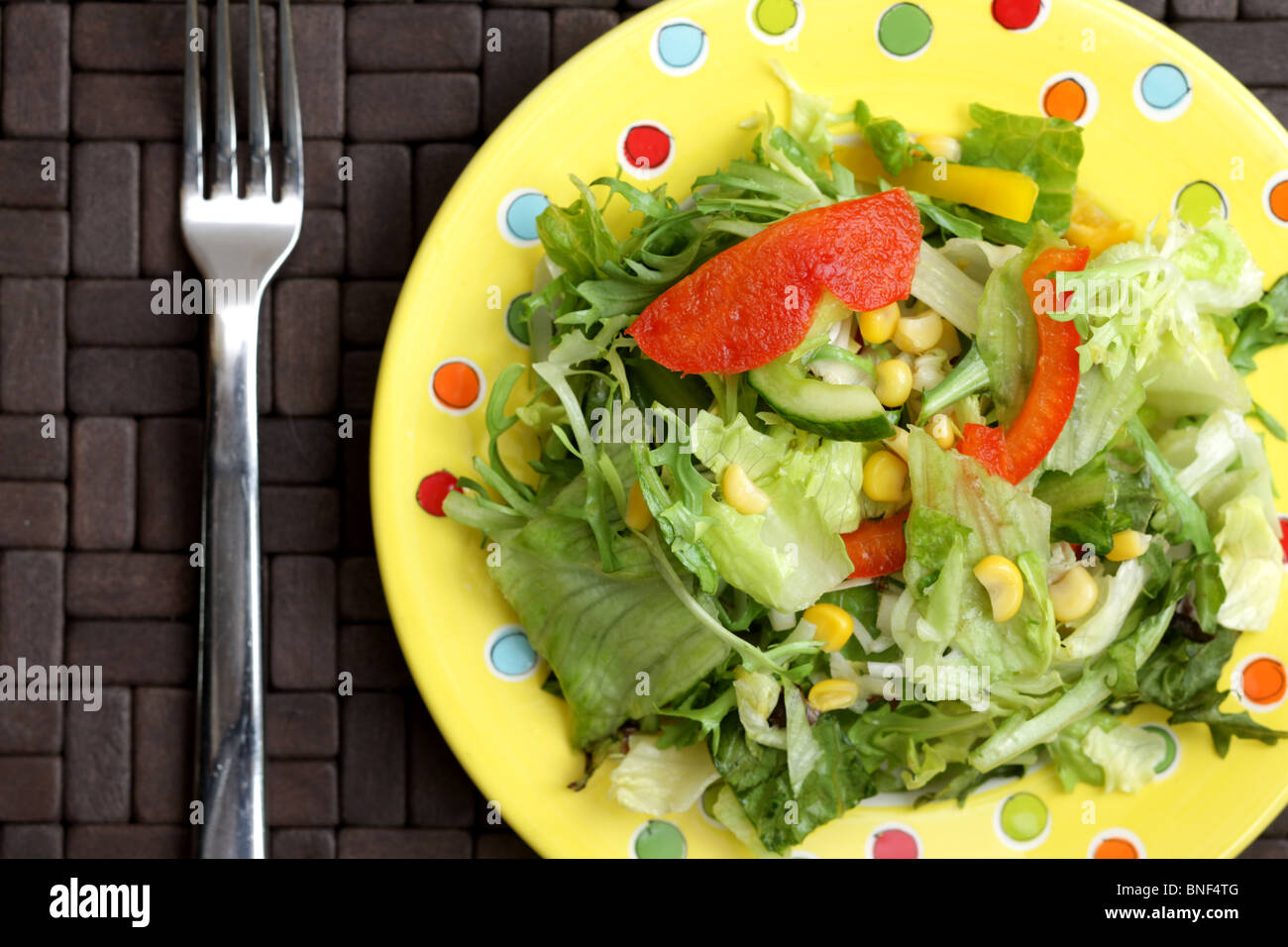 Assiette santé frais de l'été Jardin mixte croustillant salade de laitue Concombre poivrons rouges et de maïs sur une table sans les gens Banque D'Images