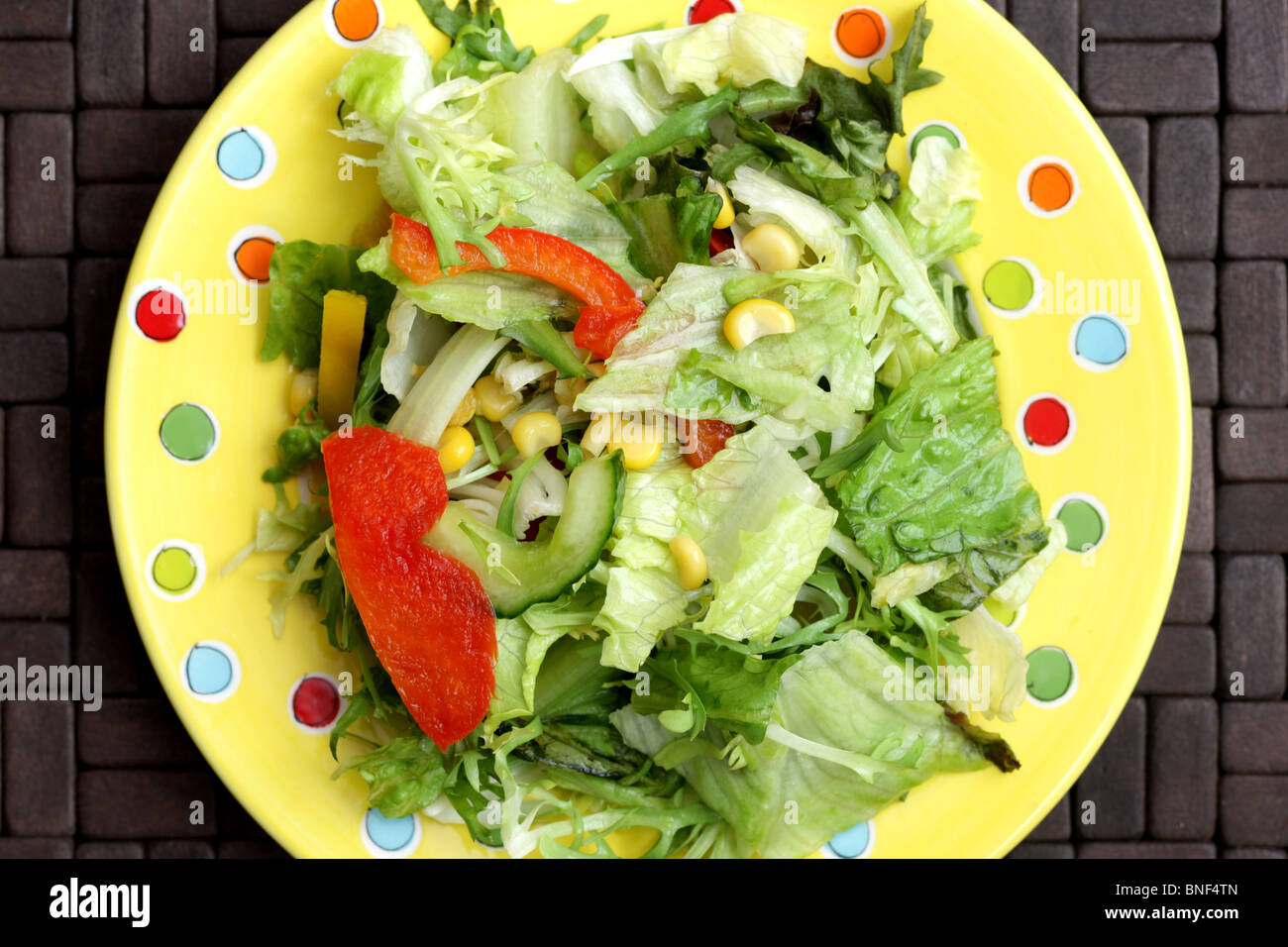 Assiette santé frais de l'été Jardin mixte croustillant salade de laitue Concombre poivrons rouges et de maïs sur une table sans les gens Banque D'Images