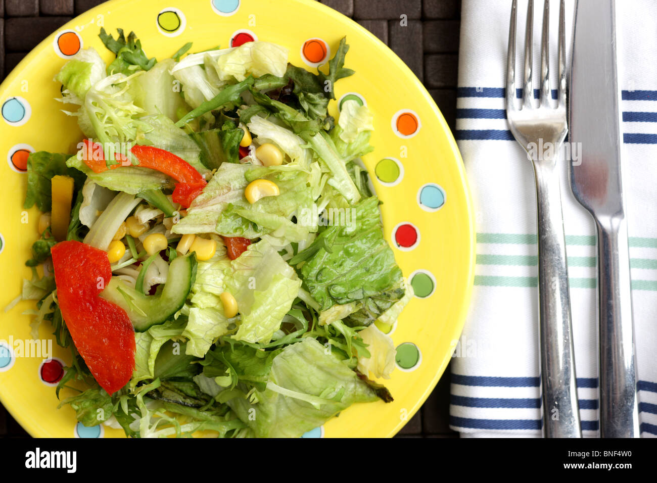 Assiette santé frais de l'été Jardin mixte croustillant salade de laitue Concombre poivrons rouges et de maïs sur une table sans les gens Banque D'Images