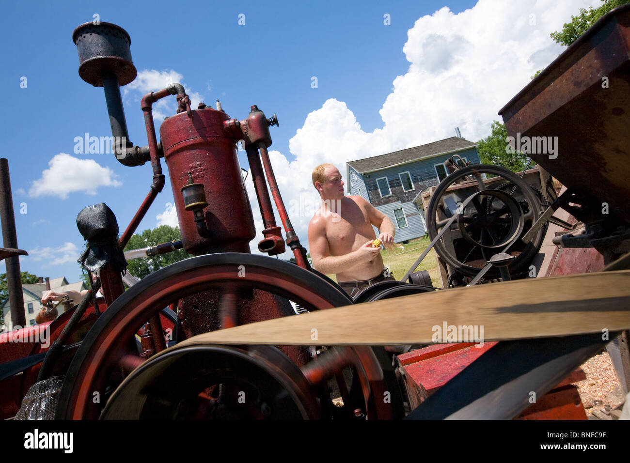 L'homme l'exploitation d'un bombardement de maïs à une machine à vapeur et gaz antique show à Fort Hunter, le canal Érié. Banque D'Images