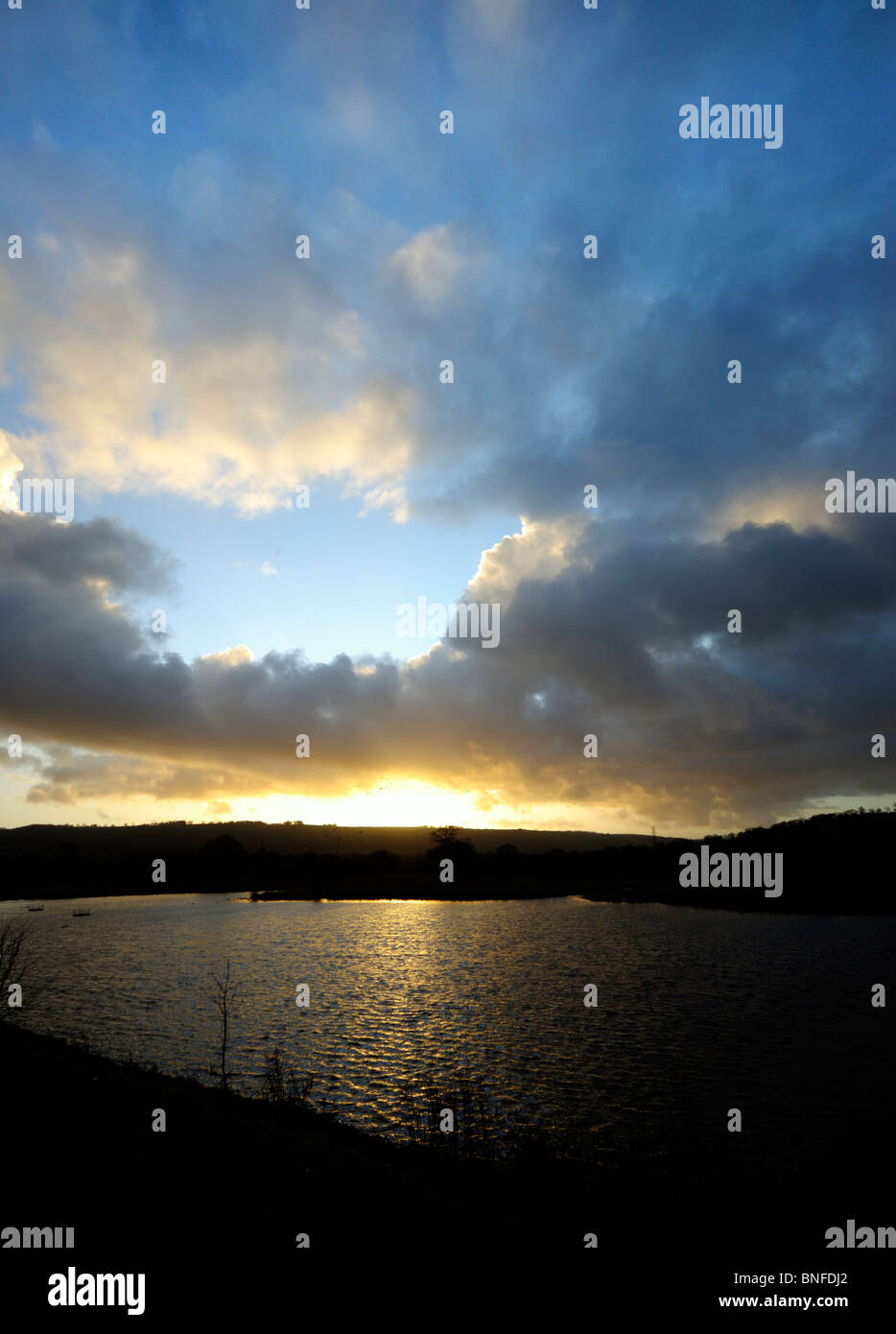 Coucher de soleil sur un lac avec des nuages et ciel bleu Banque D'Images