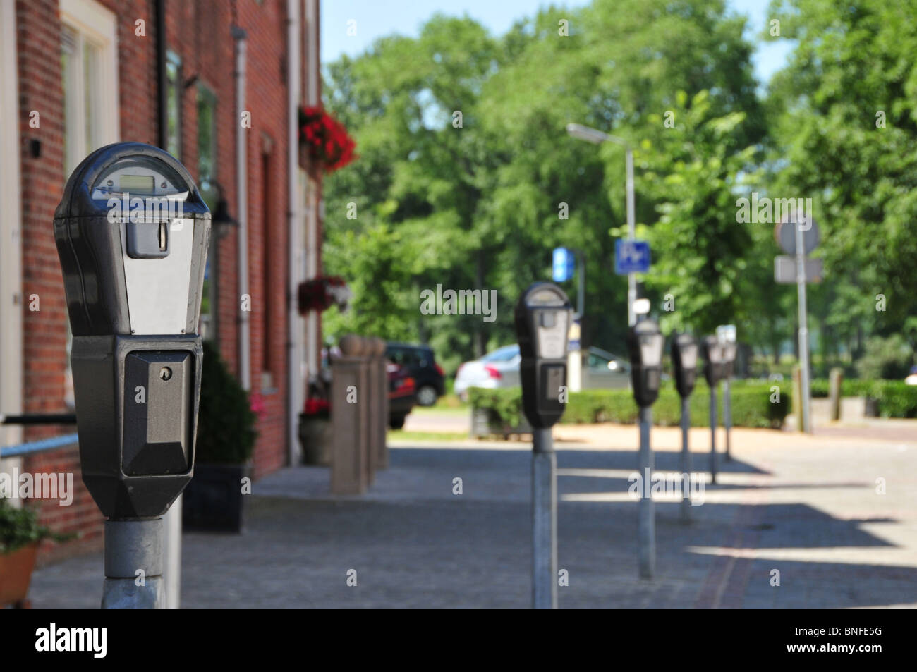 Rangée de parcomètres sur des aires de stationnement vide - differential focus - focus sharp sur le premier parking meter. Banque D'Images