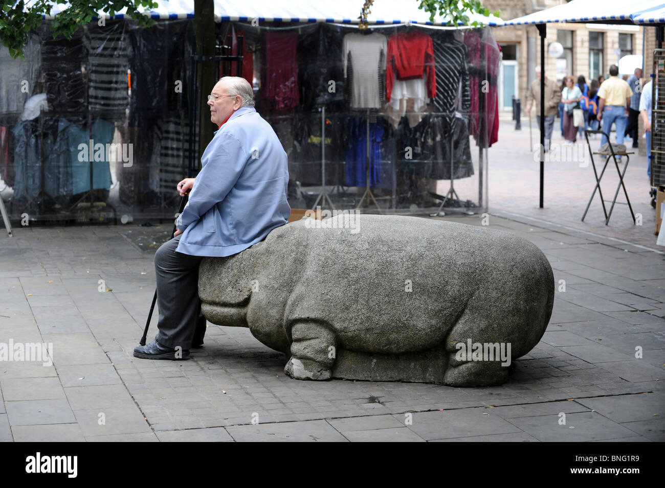 Homme âgé prendre du repos sur un siège d'hippopotames Walsall West Midlands England Uk Banque D'Images