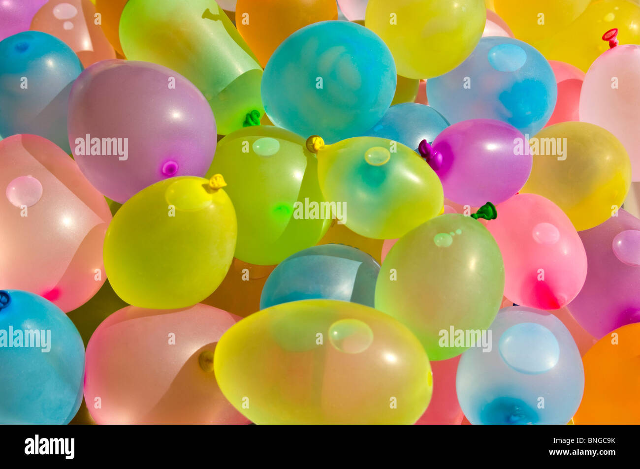 Close up horizontale de centaines de ballons de latex coloré rempli d'eau en vue d'une lutte de l'eau. Banque D'Images