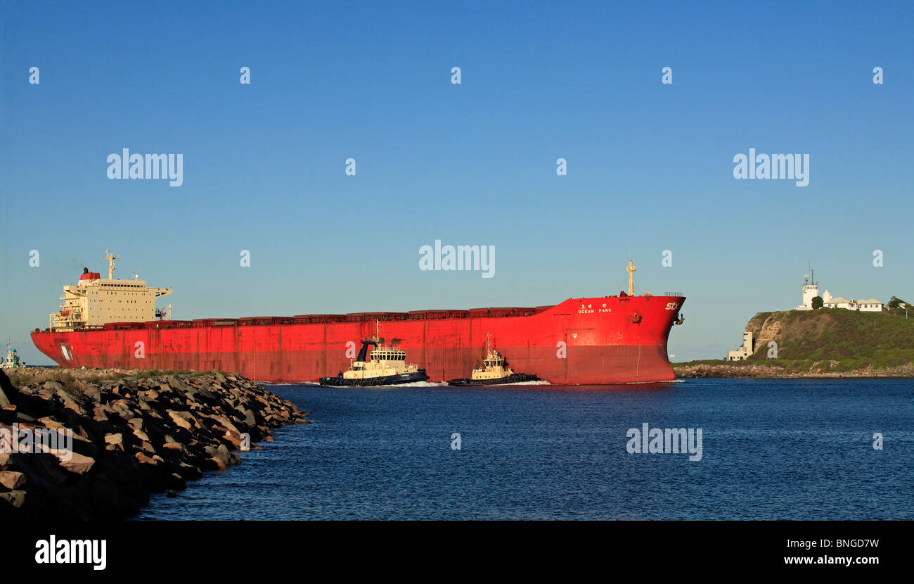 Cargo entrant dans la rivière Hunter sur son chemin vers le port de Newcastle, NSW, Australie. Il y a trois remorqueurs assistant Banque D'Images