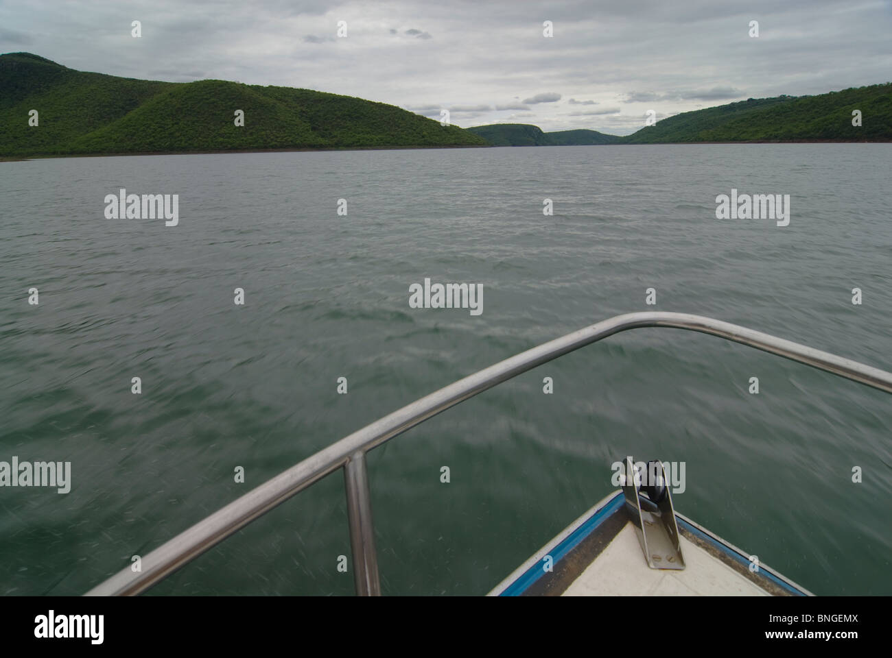 Flou de mouvement dans les zones inférieures de l'eau avec plus de cast ciel au-dessus. High angle d'un arc bateaux entouré d'eau. Deux pièces de terre reliées par un mur de barrage. Banque D'Images