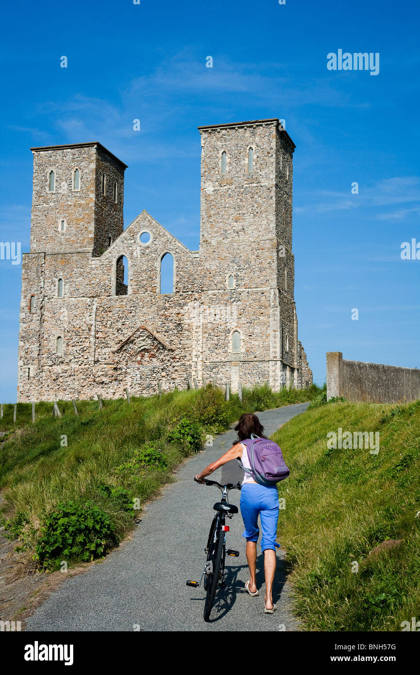 Les touristes à marcher en direction de Reculver château sur la côte du Kent. Tours jumelles de Saint Mary's Church Banque D'Images