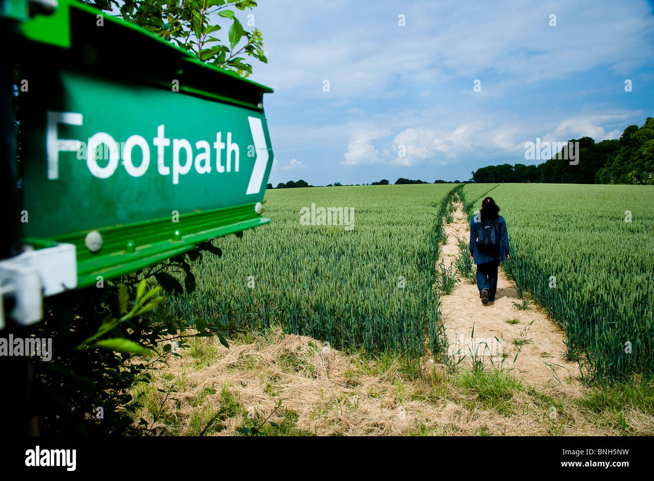 Sentier public vert panneau dans la campagne du Kent, femme marche sur sentier Banque D'Images