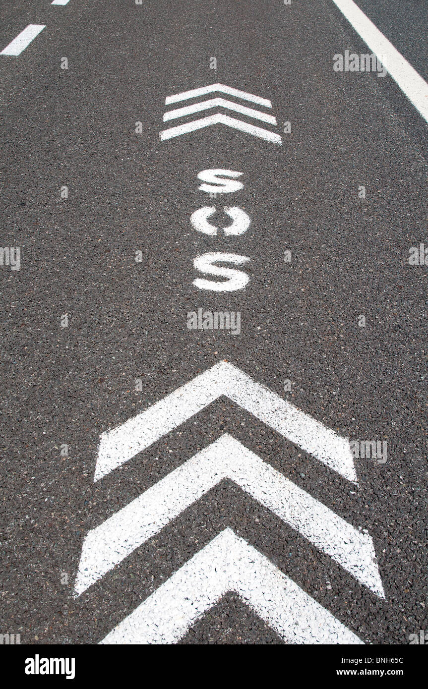 Re signer avec les flèches de direction sur bande d'arrêt d'urgence d'une autoroute Banque D'Images