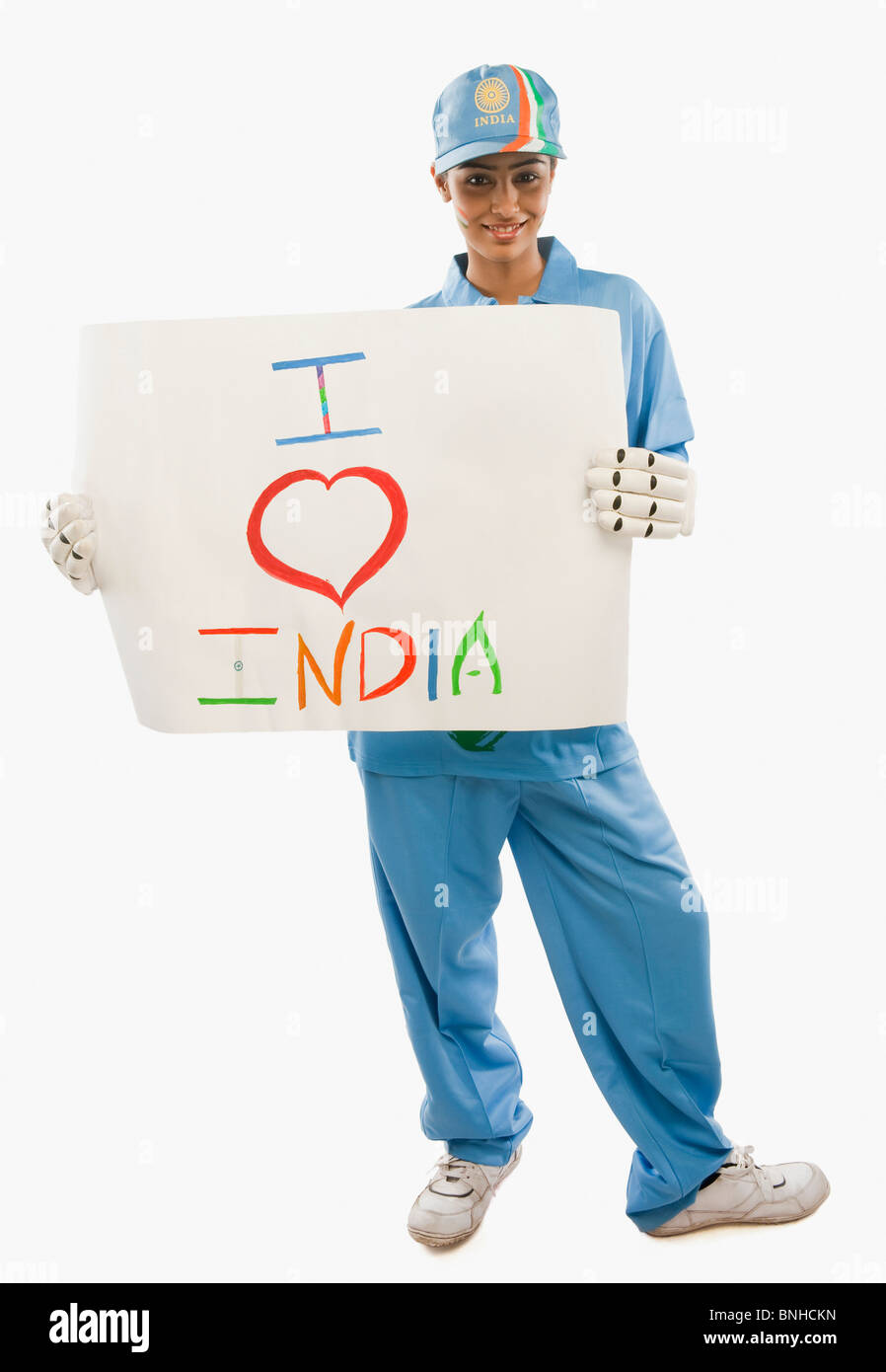 Femme en uniforme de cricket holding a placard avec texte j'aime l'Inde écrit dessus Banque D'Images