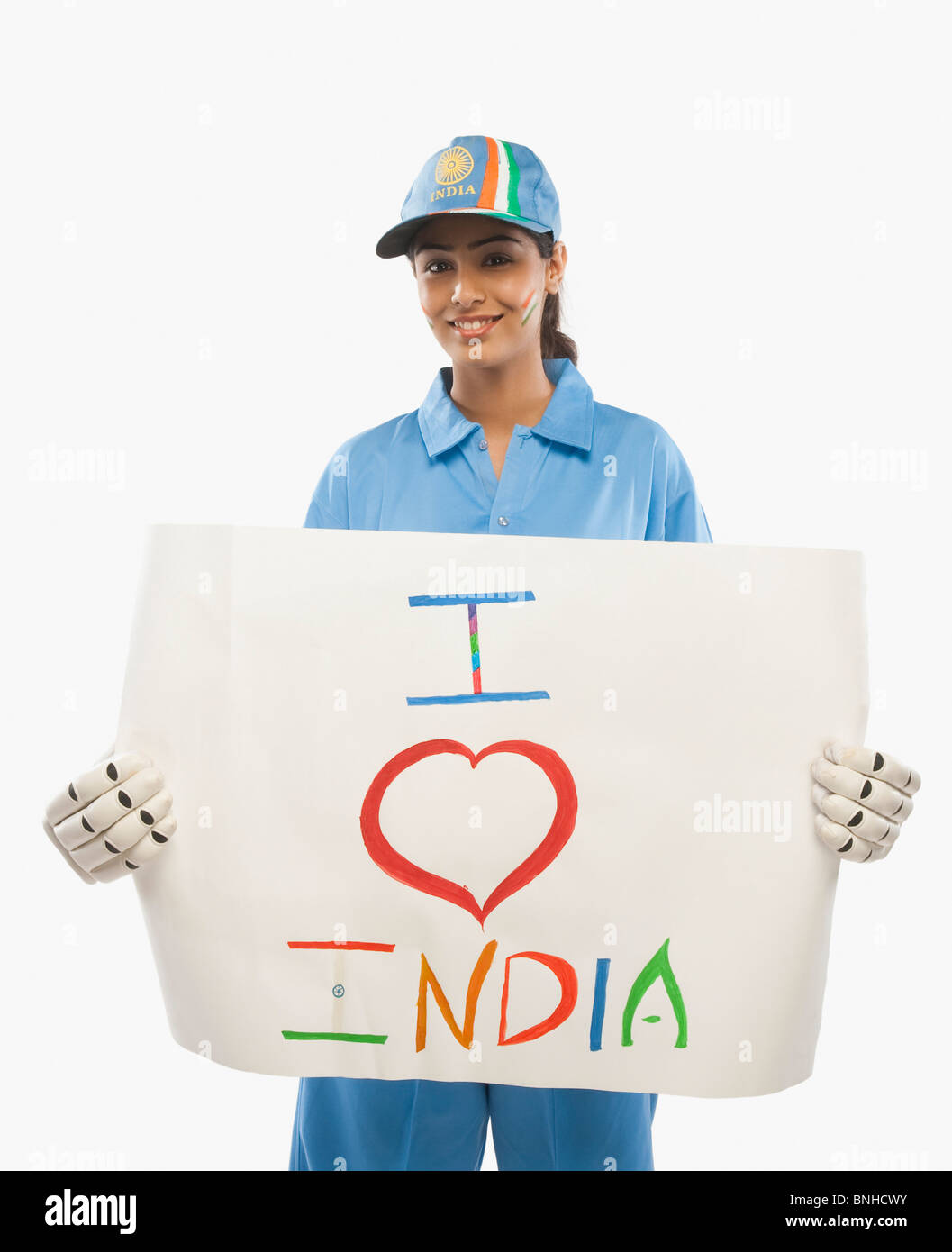 Femme en uniforme de cricket holding a placard avec texte j'aime l'Inde écrit dessus Banque D'Images