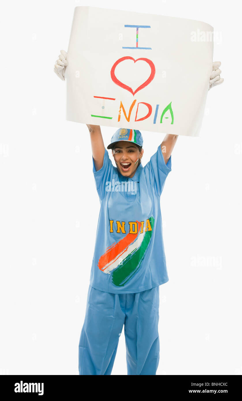 Femme en uniforme de cricket holding a placard avec texte j'aime l'Inde écrit dessus Banque D'Images