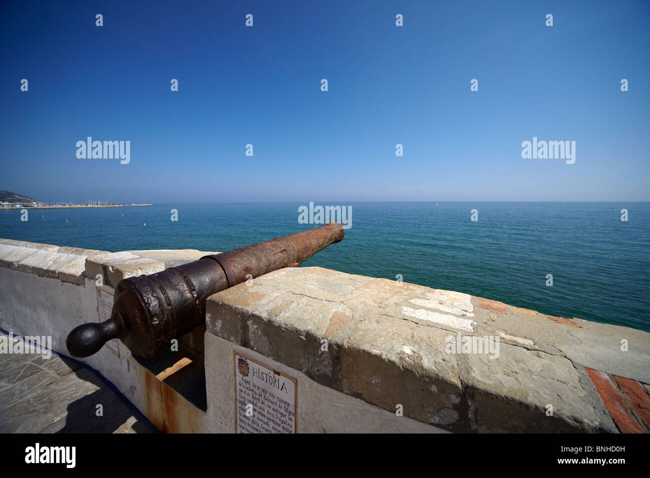 L'Espagnol ancien canon sur le quai de la ville de Sitges en fond de mer et ciel bleu Banque D'Images