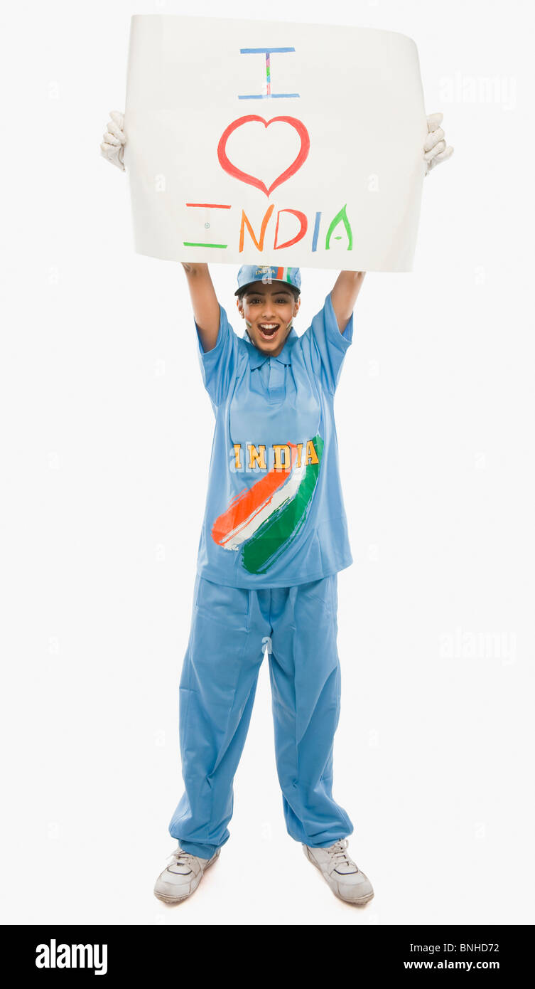 Femme en uniforme de cricket holding a placard avec texte j'aime l'Inde écrit dessus Banque D'Images