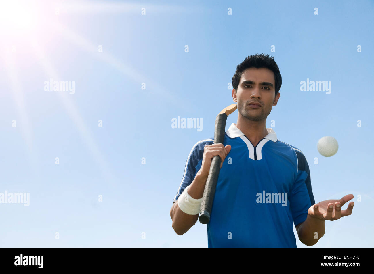 Homme tenant un bâton de hockey avec une balle Banque D'Images