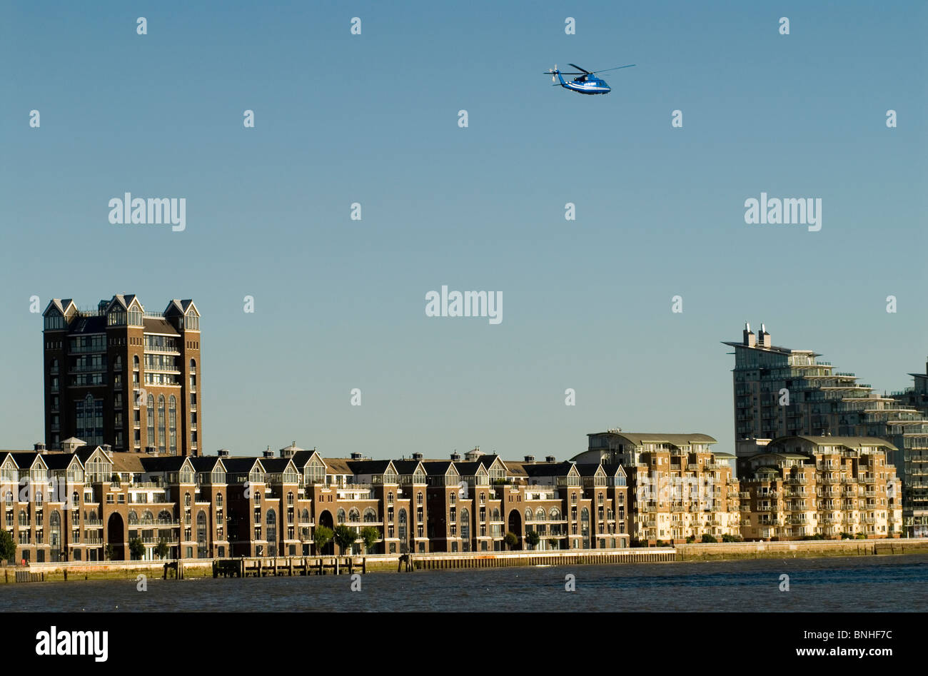 Hélicoptère au décollage sur la Tamise à l'héliport de Battersea de Londres. Uk. Trade Tower à quai de plantation. Banque D'Images