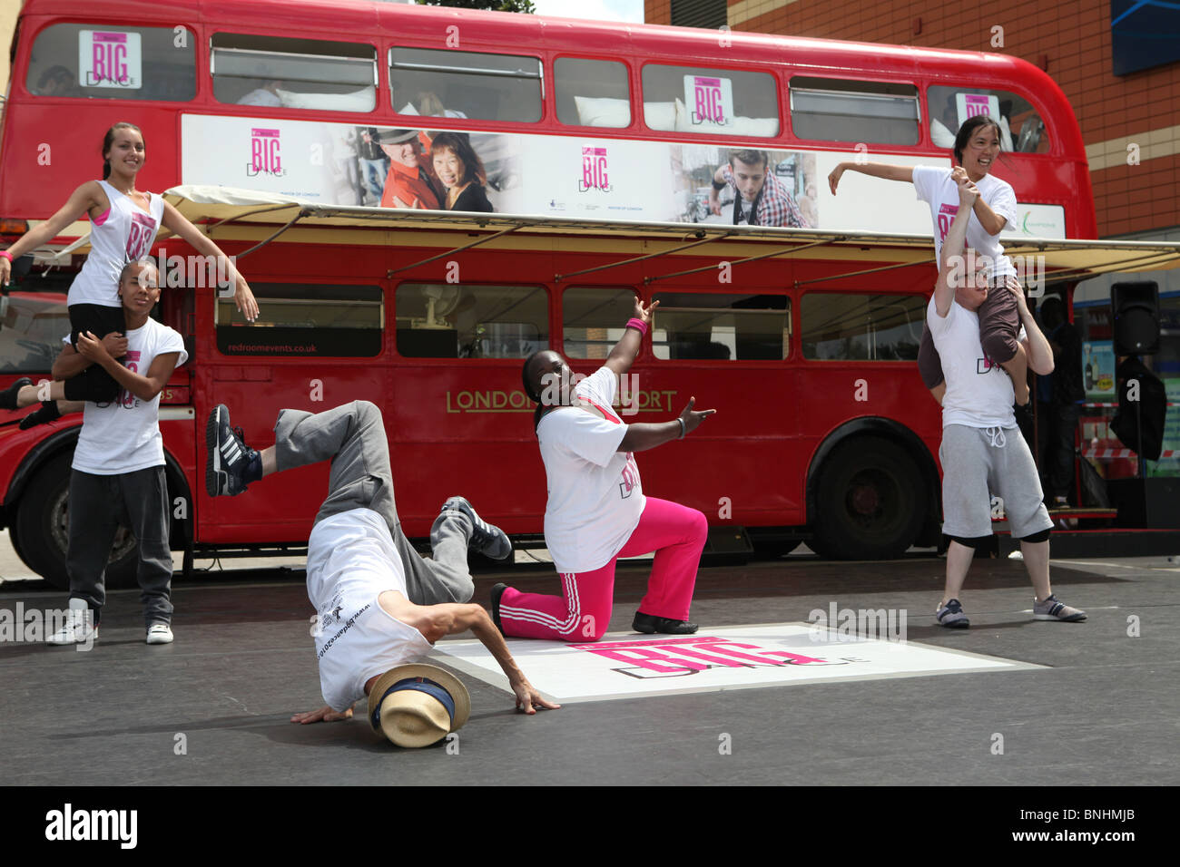 La t mobile flash mob dance danse équipe lors d'un événement à Edmonton au nord de Londres. Il y a un vieux bus rouge de Londres en th Banque D'Images