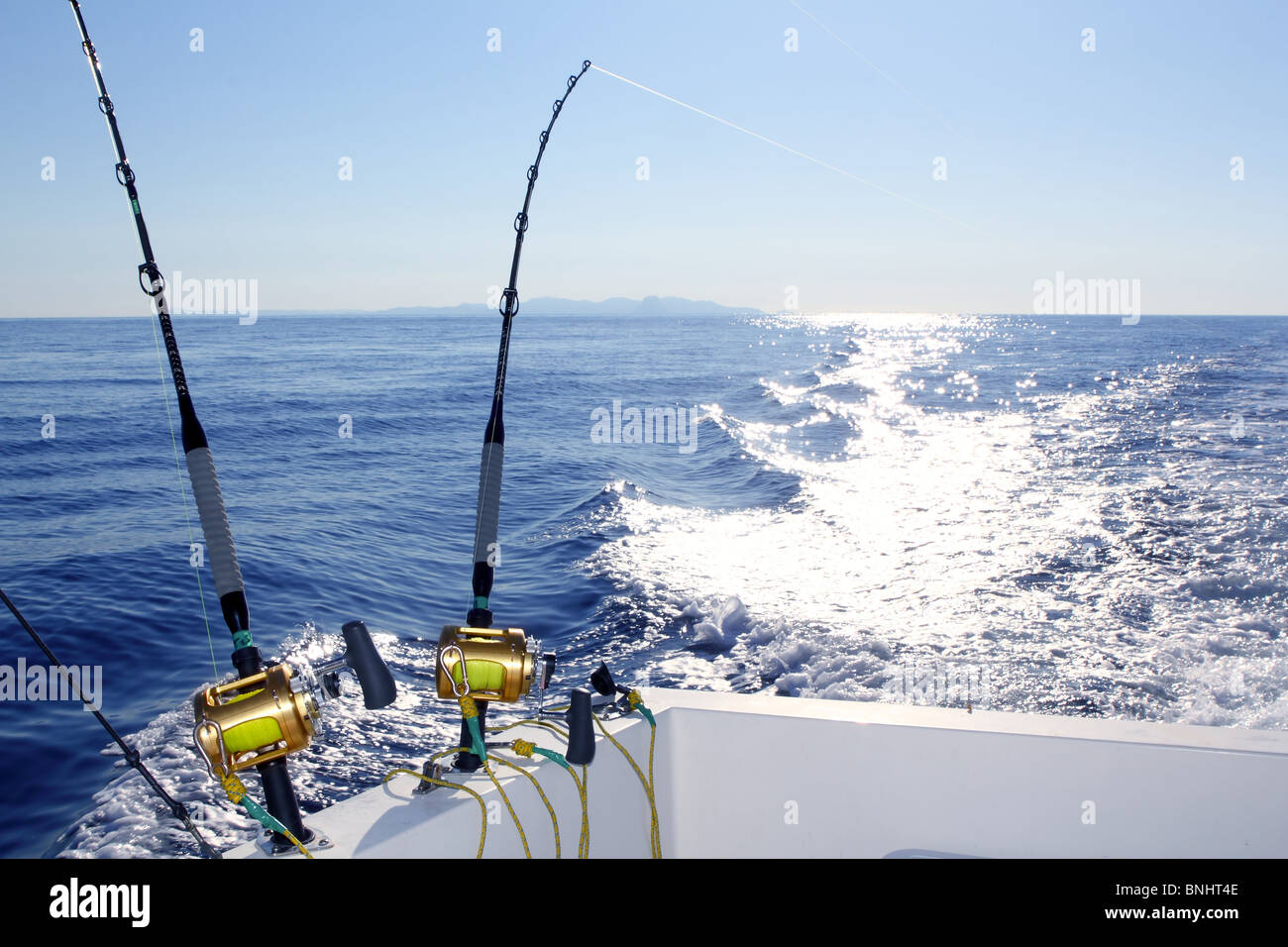 La pêche à la traîne du bateau de pêche en mer moulinets rod service  réflexion mer horizon Photo Stock - Alamy