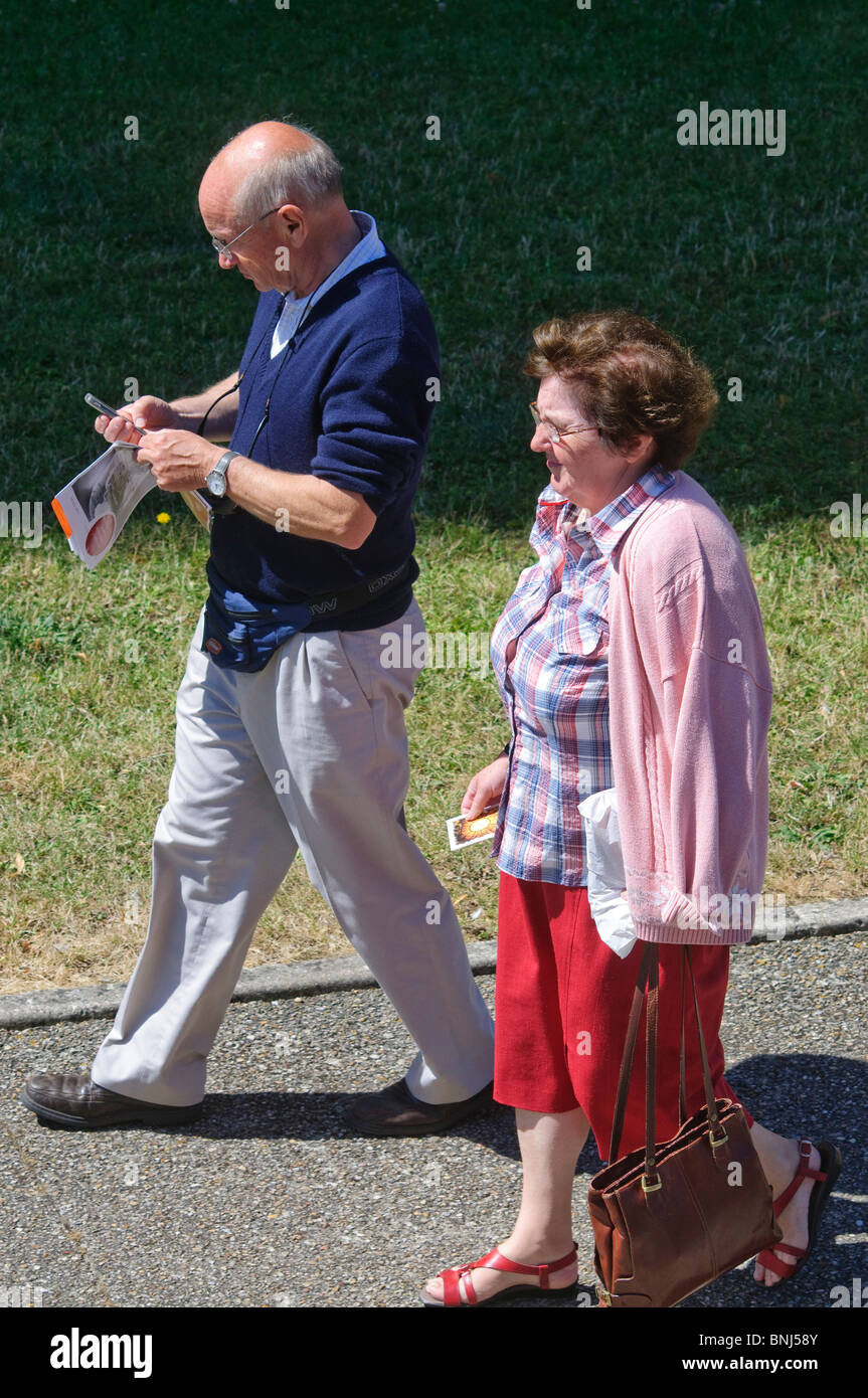 Personnes âgées en train de marcher le long de pavement - France. Banque D'Images