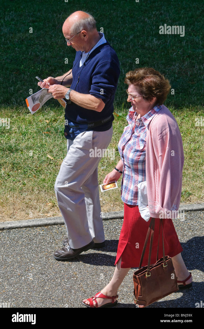 Personnes âgées en train de marcher le long de pavement - France. Banque D'Images