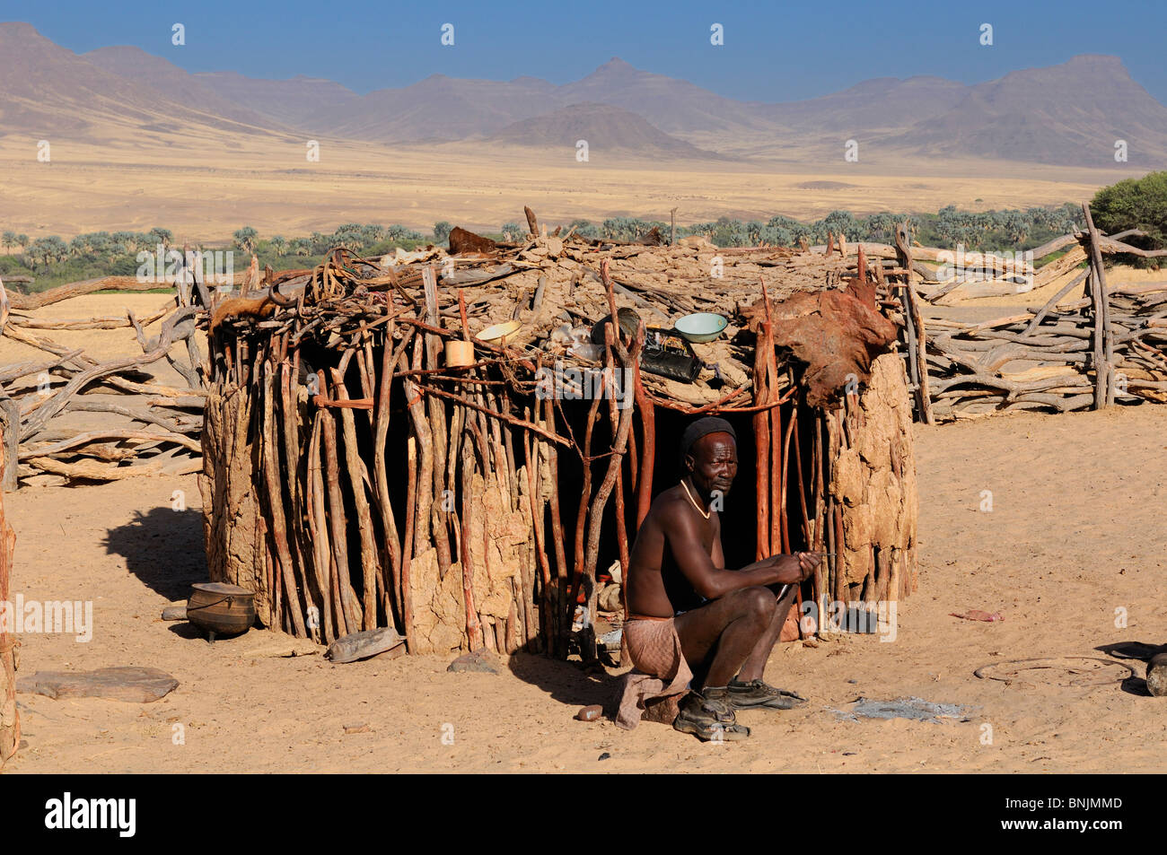 Homme Himba village Himba Purros Kunene Kaokoland Namibie Région Afrique Voyage Nature hut savane steppe Banque D'Images